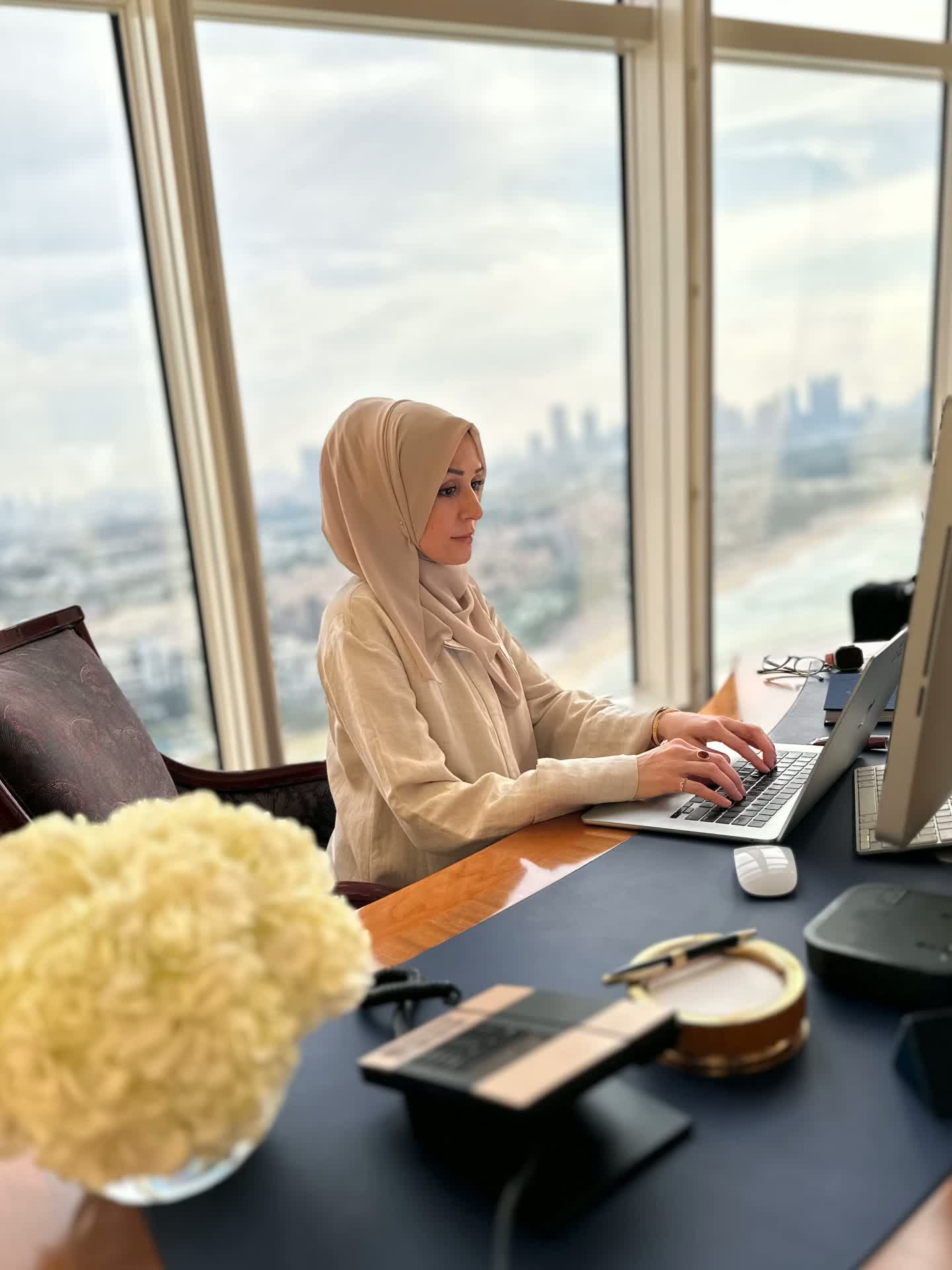Zohra Hussaini working at a desk in a high-rise office