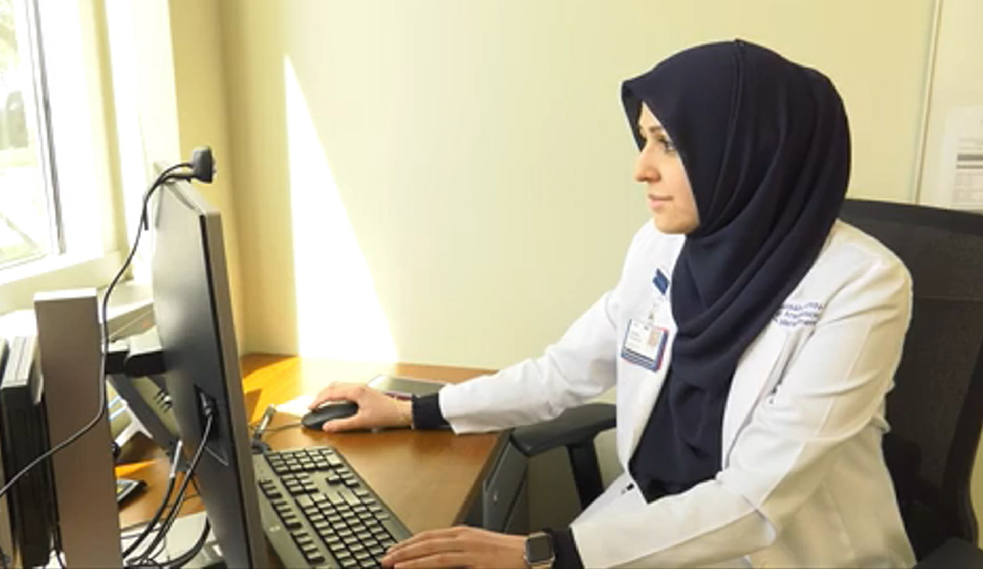 Zohra Hussaini reviewing a patient chart at a clinic workstation